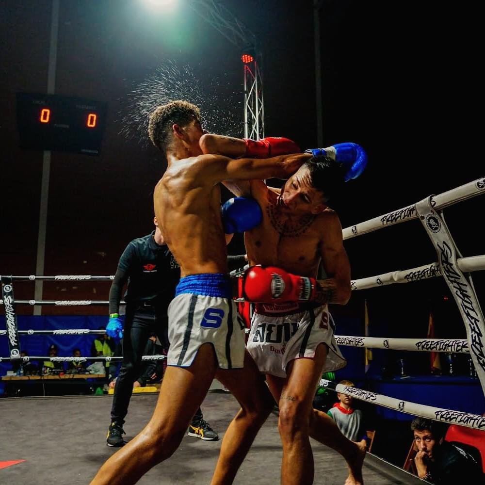 Andre Fernández y su rival intercambiando golpes en el centro del ring